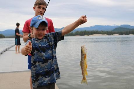 kid holding a trout on fishing line