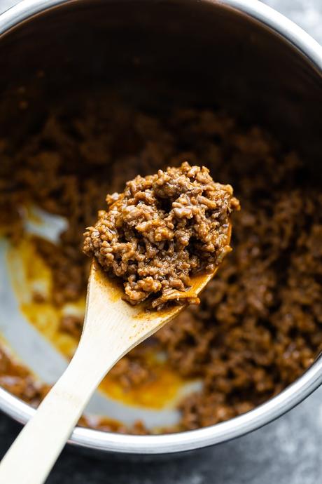 spoon with taco meat being held over instant pot