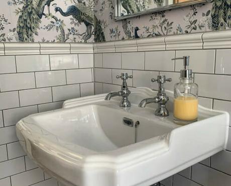 a fresh white basin in a white tiled bathroom