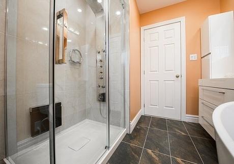 A bright bathroom with a large shower area and a sparkling clean shower screen