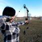 Woman shooting compound bow at target