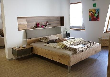 A bedroom with walls painted in a light cream color and a large window