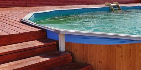 Reasons You Should Buy An Above-Ground Pool adult above ground frame swimming pool with wooden patio deck flooring