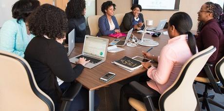 women sitting on office chairs with rollerblade wheels