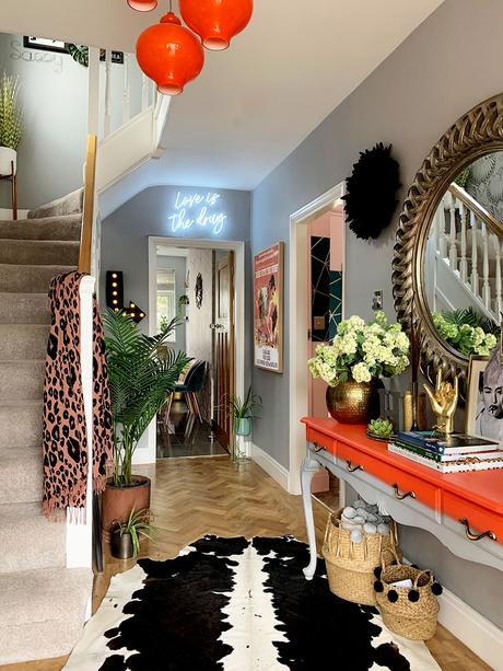 Eclectic hallway inspiration - pale gray and bright orange color palette with cowhide rug and herringbone floor