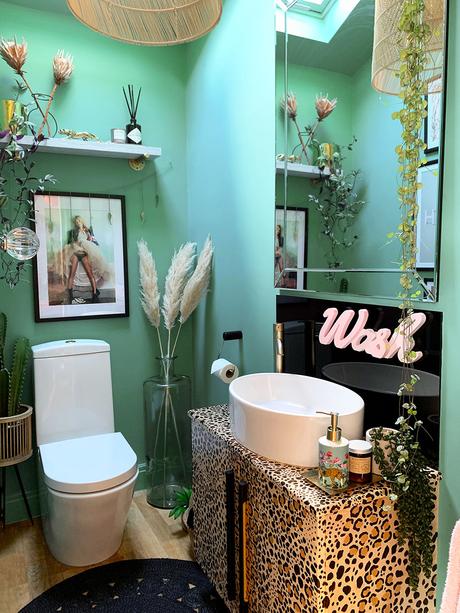 Quirky bathroom decor. Green and black color palette with leopard print wash stand 