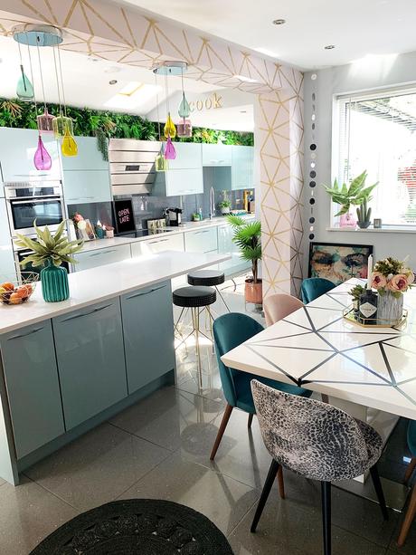 Pink and blue modern kitchen with colourful glass lights and geometric wallpaper