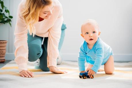a mother encouraging baby to crawl