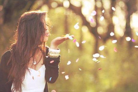 a lady blowing petals