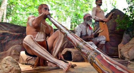 Yirrganydji Aboriginal men play Aboriginal music on didgeridoo and wooden instrument during Aboriginal culture show in Queensland, Australia