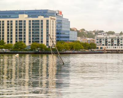 Ripples, ducks, a mast, buildings