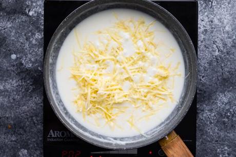 overhead view adding cheese to the cheese sauce in the final step