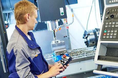 Service engineer operating CNC milling machine at factory. Image Courtesy of iStockPhoto