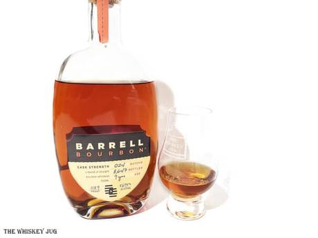 White background tasting shot with the Barrell Bourbon Batch 024 bottle and a glass of whiskey next to it.