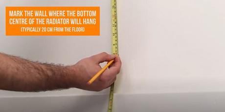 hand marking a line on a wall