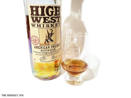 White background tasting shot with the High West American Prairie Bourbon Barrel Select bottle and a glass of whiskey next to it.