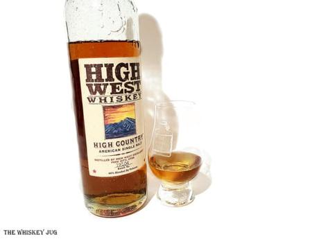 White background tasting shot with the High West High Country Single Malt bottle and a glass of whiskey next to it.