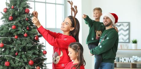 family placing ornaments on the christmas tree