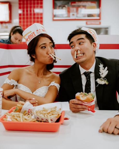 Bride and groom having hamburger and fries