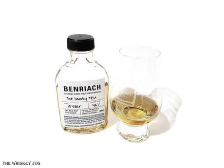 White background tasting shot with the BenRiach The Smoky Ten bottle and a glass of whiskey next to it.