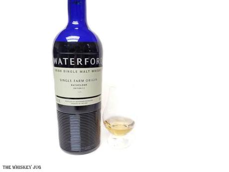 White background tasting shot with the Waterford Rathclogh 1.1 bottle and a glass of whiskey next to it.