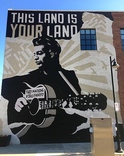 This Land is Your Land mural on wall of Woody Guthrie Center in Tulsa