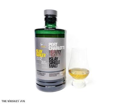 White background tasting shot with the Port Charlotte Islay Barley 2012 bottle and a glass of whiskey next to it.