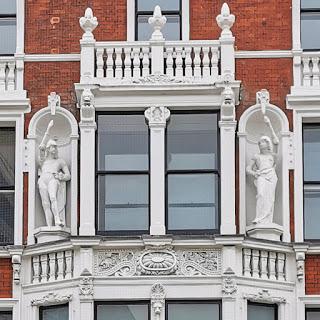 Photograph showing the two figures in niches. Their outstretched arms can be more clearly seen: the forearms look disproportionately long.