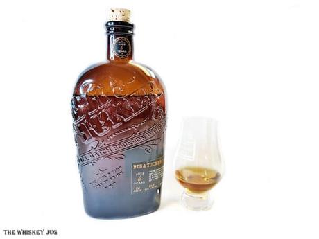 White background tasting shot with the Bib and Tucker Bourbon 6 Years bottle and a glass of whiskey next to it.