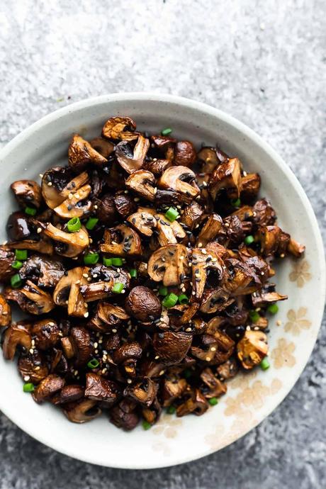 air fryer mushrooms in a bowl with sesame seeds and green onions