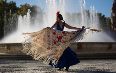 Beautiful woman dancing flamenco near the fountain