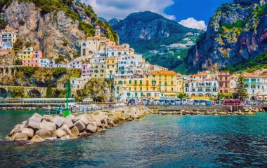 Enchanting Travels Italy Tours Wonderful Italy. The small haven of Amalfi village with a turquoise sea and colorful houses on the slopes of the coast