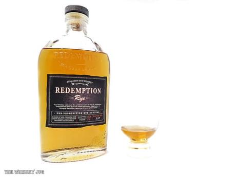 White background tasting shot with the Redemption Rye bottle and a glass of whiskey next to it.