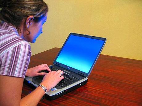 English language learning: Woman typing on laptop