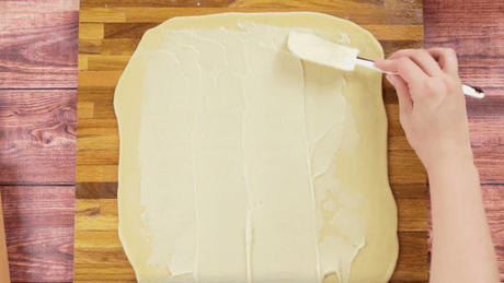 Spread shortening mixture onto dough