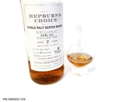 White background tasting shot with the 2009 Hepburn's Choice Caol Ila 7 Years bottle and a glass of whiskey next to it.