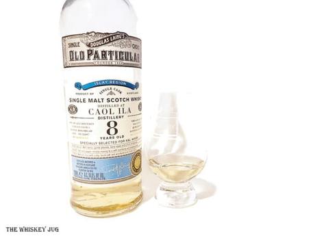 White background tasting shot with the 2010 Old Particular Caol Ila 8 Years bottle and a glass of whiskey next to it.