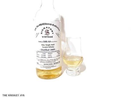White background tasting shot with the 2009 Signatory Caol Ila 8 Years bottle and a glass of whiskey next to it.