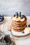 These gluten-free & vegan Banana Blueberry Pancakes are thick, fluffy, and loaded with blueberries! Made in the blender, they come together quickly and reheat well, so you can make them ahead of time for a quick breakfast.