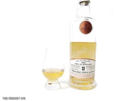 White background tasting shot with the G&M Discovery Caol Ila 13 Years bottle and a glass of whiskey next to it.