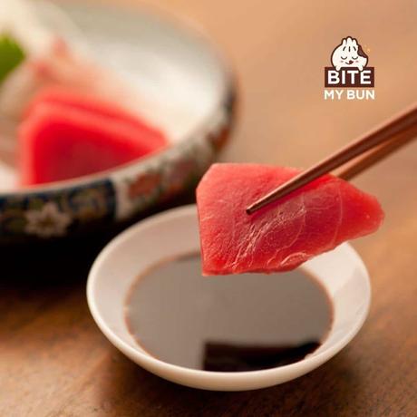 Tuna sashimi dipping with chopsticks in soy sauce