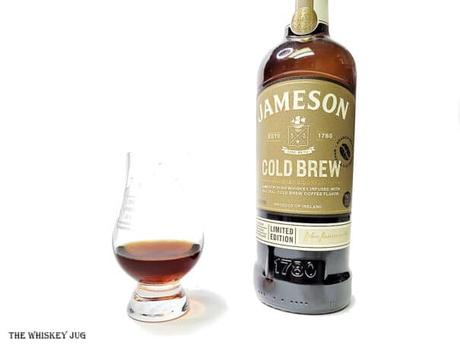 White background tasting shot with the Jameson Cold Brew bottle and a glass of whiskey next to it.