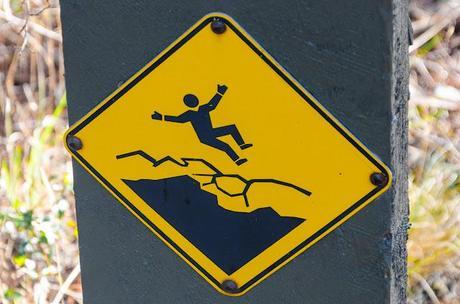 man falling on danger sign