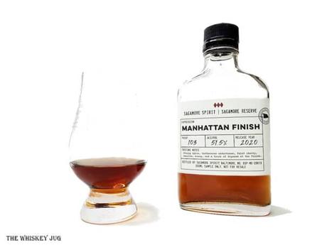 White background tasting shot with the Sagamore Reserve Manhattan Finish bottle and a glass of whiskey next to it.