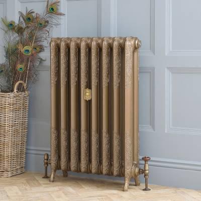 gold cast iron central heating radiator in front of a blue wall