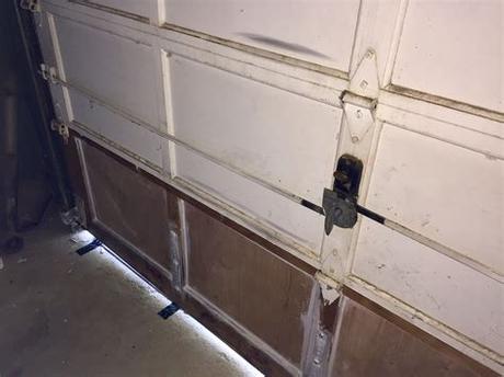 To open it up, all you need to do is thread a coat hanger or hooked piece of wire through the top of the door and open the emergency latch (which can also be done by the rope many. Removing old style garage door lock - DoItYourself.com ...