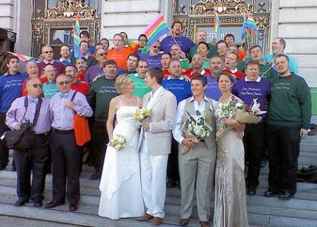 The San Francisco Gay Men's Chorus performs on the steps of San Francisco City Hall as gay couples marry inside.