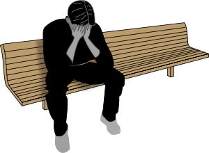 A depressed man sitting on a bench