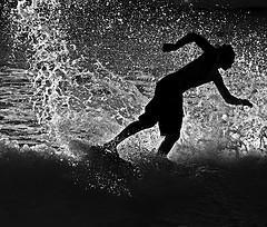 black and white image of a surfer riding the waves