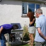 David Henshaw pointing out details of a small-scale solar hot water system